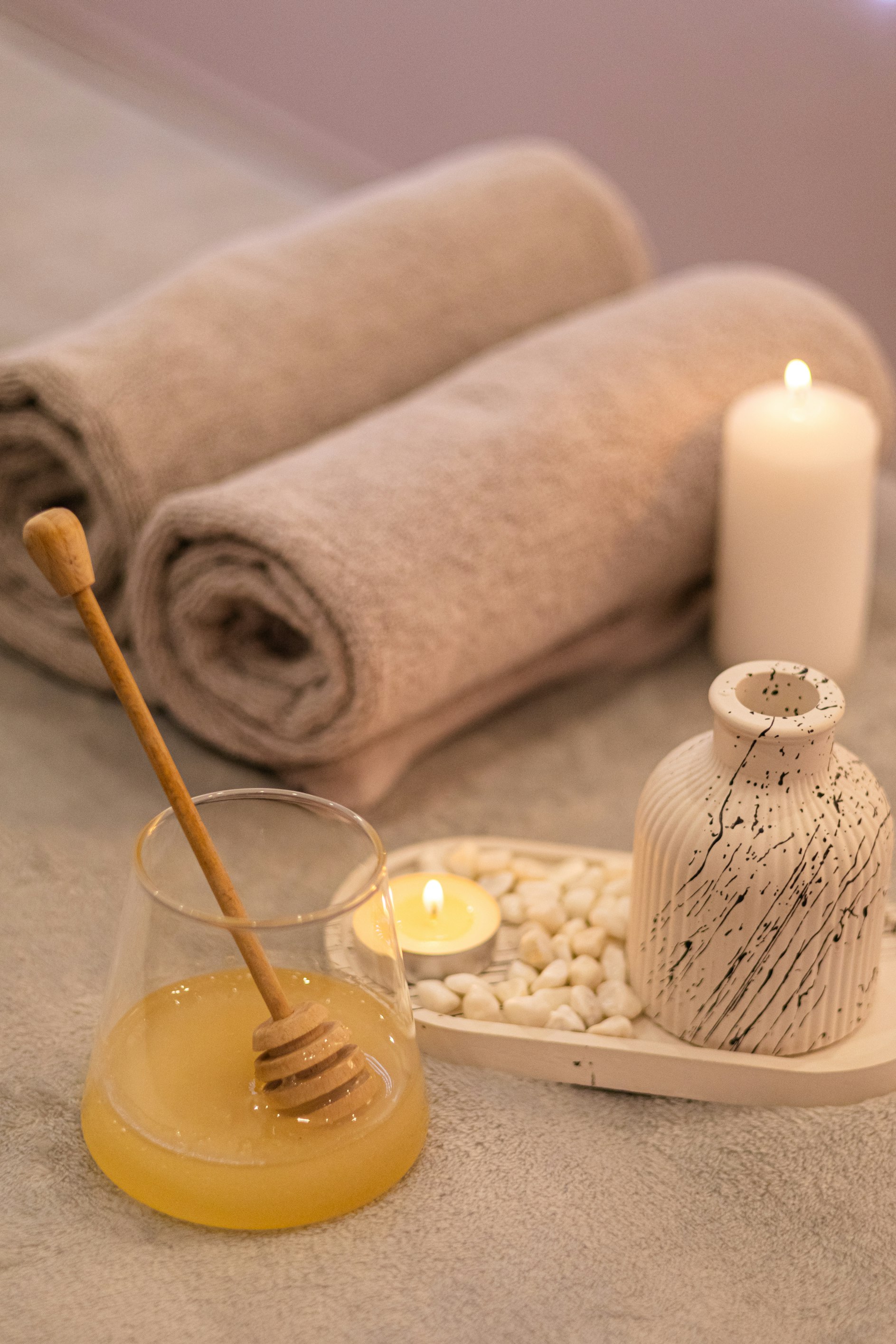 Góc trị liệu spa với khăn cuộn, nến thơm và mật ong